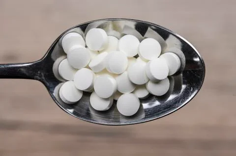Pills in spoon Stock Photos