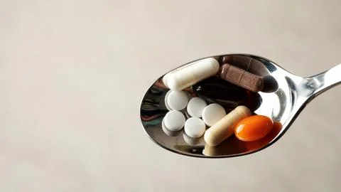 Pills on a spoon Stock Photos