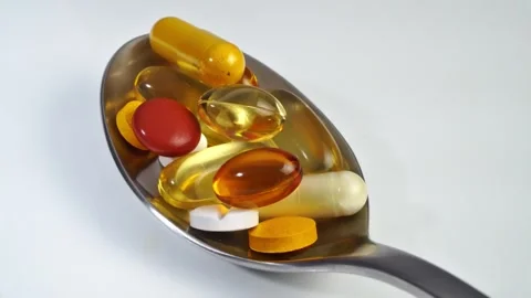 Pills on a spoon on white background Stock Footage 272977709