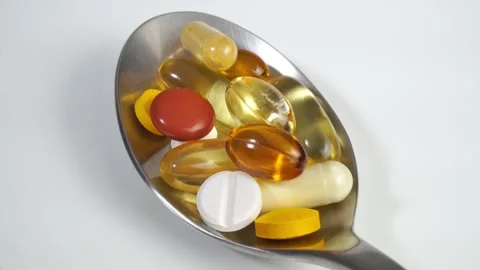 Pills on a spoon on white background Stock Footage 274342846