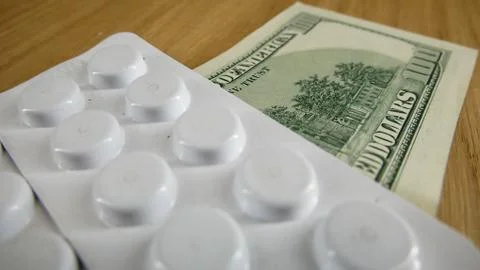 Pills on the table in white plastic and dollars on the table. Stock Illustration