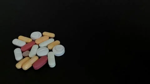 Pills, Tablets, and Capsules Isolated on Black Background Vídeos de archivo 343480400