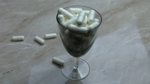 Pills. White tablets fall into a glass 스톡 동영상 78339397