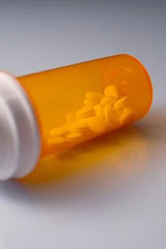 Pills in a yellow bottle on the table. Stock Photos