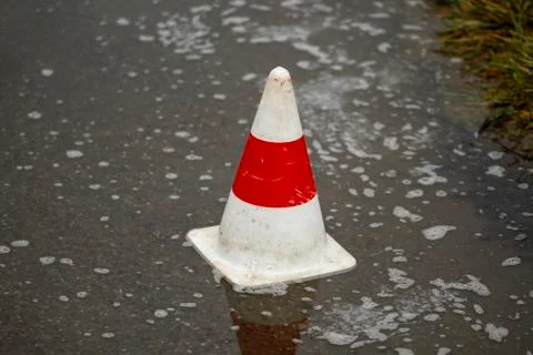 Pilone on the road in a puddle of rain Stock Photos