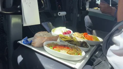 Pilot (captain) eating his crew meal during a real flight. Left low angle Video stock 249498384