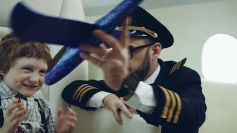 Pilot carries boy playing with blue plane toy, imagination dreaming of being a Stock Footage 111064552