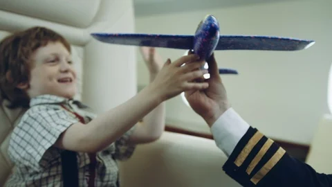 Pilot carries boy playing with blue plane toy, imagination dreaming of being a Stock Footage 111064717