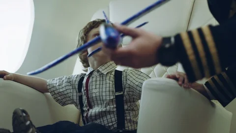 Pilot carries boy playing with blue plane toy, imagination dreaming of being a Stock Footage 111064977