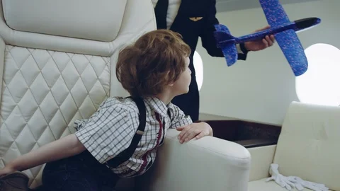 Pilot carries boy playing with blue plane toy, imagination dreaming of being a Stock Footage 111066962
