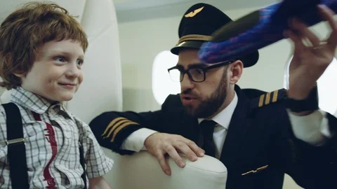 Pilot carries boy playing with blue plane toy, imagination dreaming of being a Stock Footage 111068511