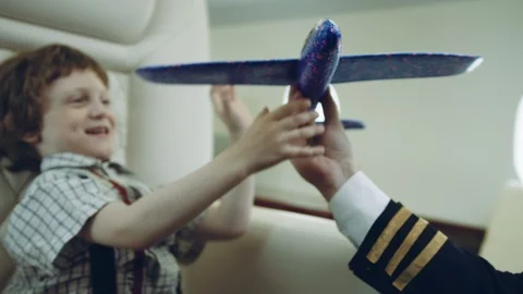 Pilot carries boy playing with blue plane toy, imagination dreaming of being a Stock Footage 111068665