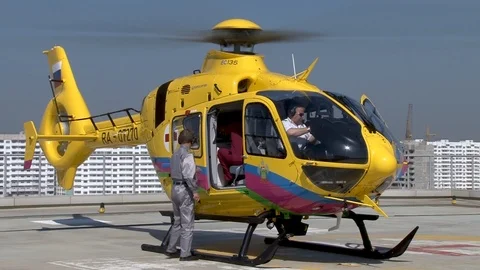 Pilot closes door and sits in cockpit medical helicopter Eurocopter EC135 . Stock Footage 106553094