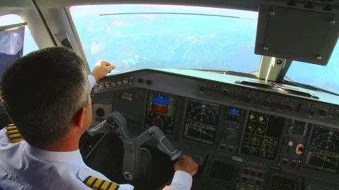 Pilot in the cockpit operate with commercial airplane in flight Stock Footage