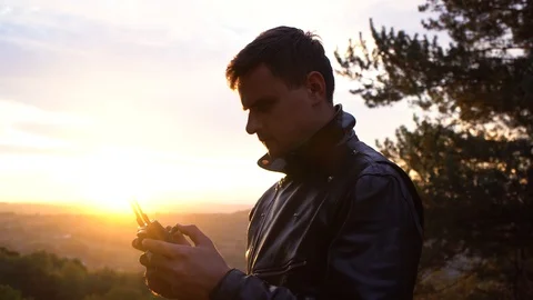 The pilot controls his quadcopter. Sunset.Close-up Stock Footage 119713226