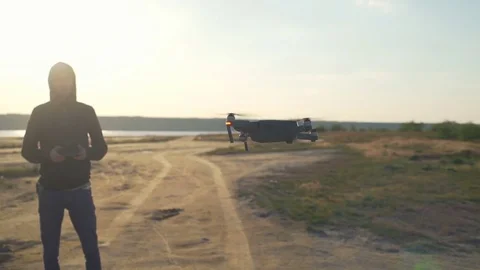 Pilot controls his quadrocopter by remote at desert middle shot slow motion Video stock 75542362