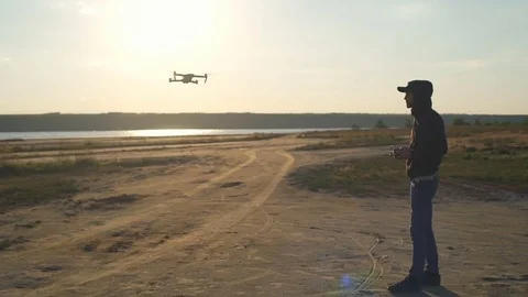 Pilot controls his quadrocopter by remote control long shot slow motion Stock Footage 75543108