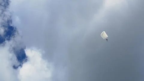 The pilot ejected from the exploded plane and descended to the ground by Stock Photos