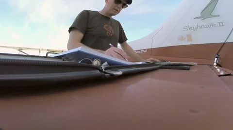 Pilot entering data into log books Video stock 40998172