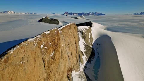 Pilot Explores Icy Rugged Terrain. Sunlit Headland Showcases Ice Plains With Stock-Footage 338360391