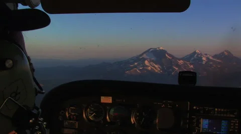 PILOT FLYING SMALL PLANE OVER MOUNTAINS AT SUNRISE Stock Footage 53282310