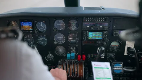 Pilot hand on throttle levers in small aircraft cockpit with flight instruments. Stock Footage 338369418