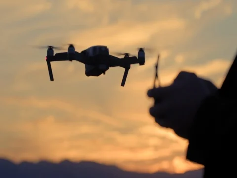 Pilot hands control drone flying in background at sunset 4K Stockbeeldmateriaal 83673698