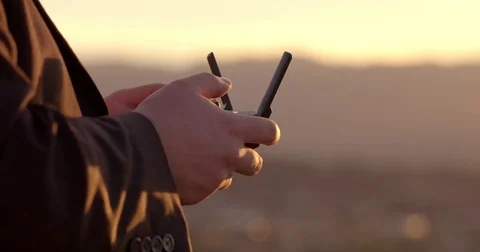 Pilot hands using drone remote control at dusk 4K Stock Footage 83672578