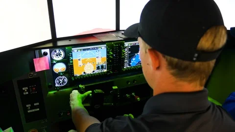 A pilot with instructor is sitting in the flight simulator and holds a yoke Stock Footage 115895989