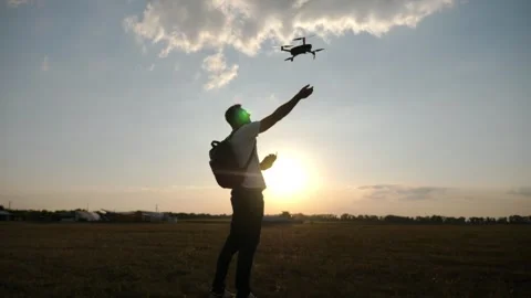 Pilot launching drone into the sky at sunset, showcasing the excitement Stock Footage 323467447