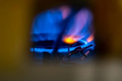Pilot light auto igniter inside a hot water heater with flames Stock Photos