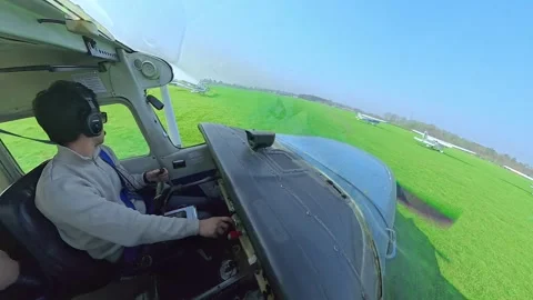 Pilot moving small airplane on a grass airfield during taxi Stock Footage 330675552