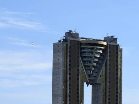 Pilot navigates between twin city skyscrapers, vshaped skyscraper with Stock Photos