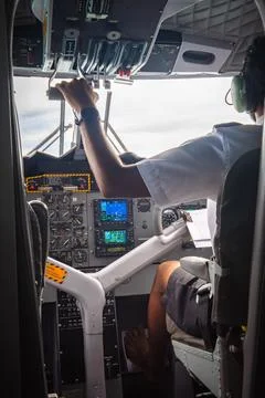 Pilot operates controls in twin engine seaplane cockpit, Maldives Foto stock