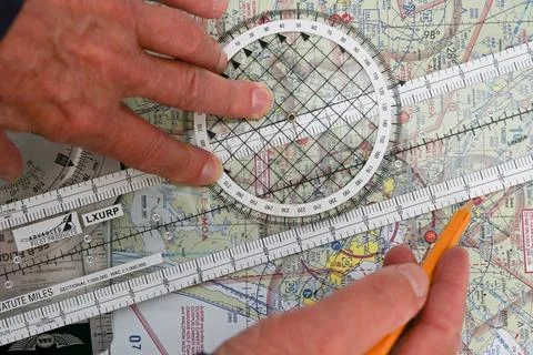 Pilot plots a flight on a sectional map for a vector from one airport to another Fotos de archivo