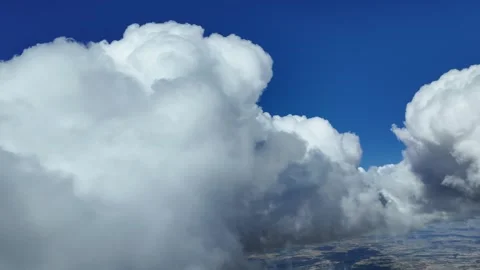 Pilot POV in a real time flight through a deep blue sky with some white Stock Footage 280380081