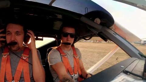 Pilot preparing for flight in a small aircraft cockpit, adjusting equipment Stock Footage 319748684