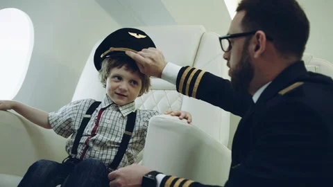 Pilot presenting for a boy his uniform cap, imagination dreaming of being a Stock Footage 111065273