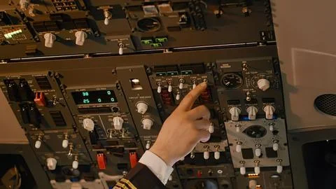 Pilot pressing button on airplane cockpit control panel Stock Photos