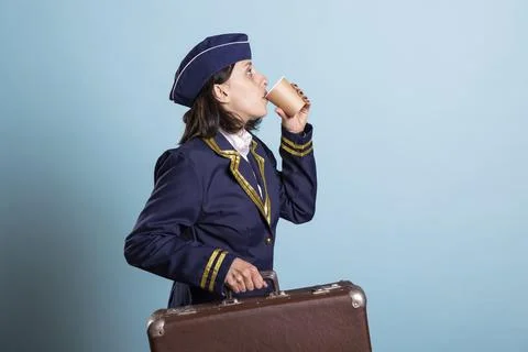 Pilot sipping coffee with suitcase 写真素材