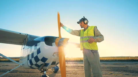 A pilot is standing beside a cropduster on a runway in an open field Stock Footage 96862844