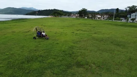 Pilot start and move a tandem paramotor on a beach in Brazil 動画素材 328349625