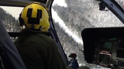 Pilot taking a sharp turn in helicopter over field of snow Stock Footage 82121135