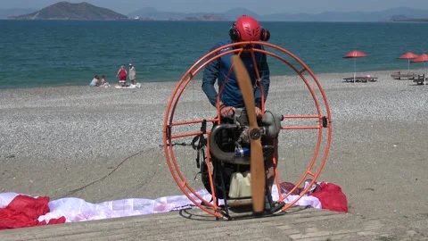 Pilot is testing the engine of his powered paragliding apparatus Stock Footage 142988969