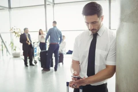 Pilot using mobile phone in waiting area Foto stock