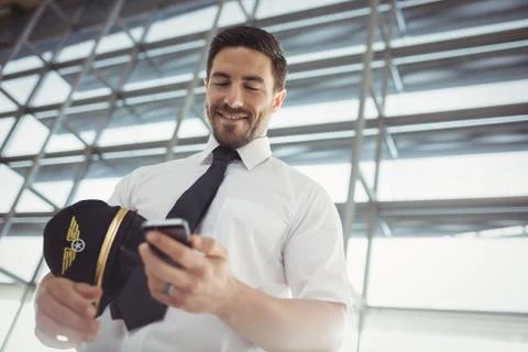 Pilot using mobile phone in waiting area Foto stock