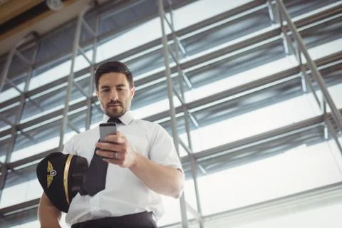 Pilot using mobile phone in waiting area Foto stock