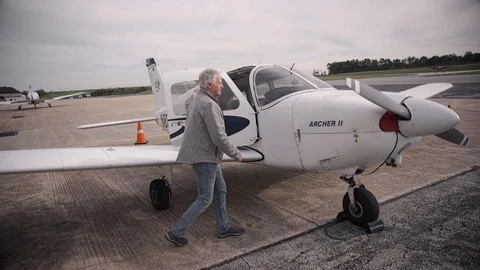 Pilot Walking around Piper Airplane Checking Oil Dipstick Stock Footage 99267693