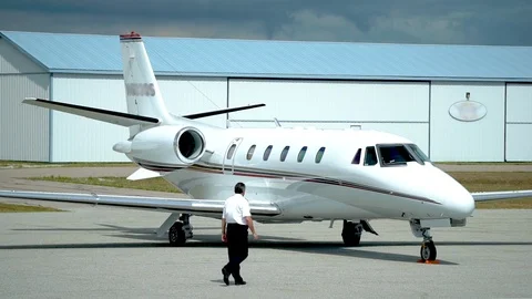 Pilot walking into private jet plane Stock Footage 120107706