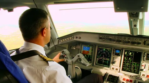 Pilots in the cockpit operate with commercial airplane in flight Stock Footage